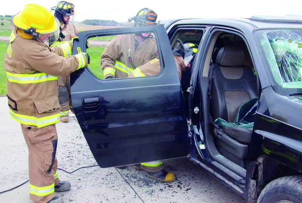 DOOR REMOVAL -- With close fire department supervision, students use the Jaws of Life to remove a door from this SUV.